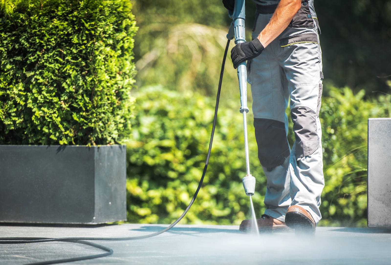 Patio Pressure Cleaning. Caucasian Men Washing His Concrete Floor Patio Using High Pressured Water Cleaner.